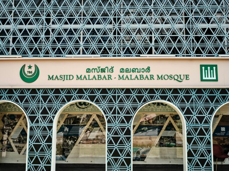 Front view of the geometric facade and sign of Masjid Malabar Mosque in Singapore.
