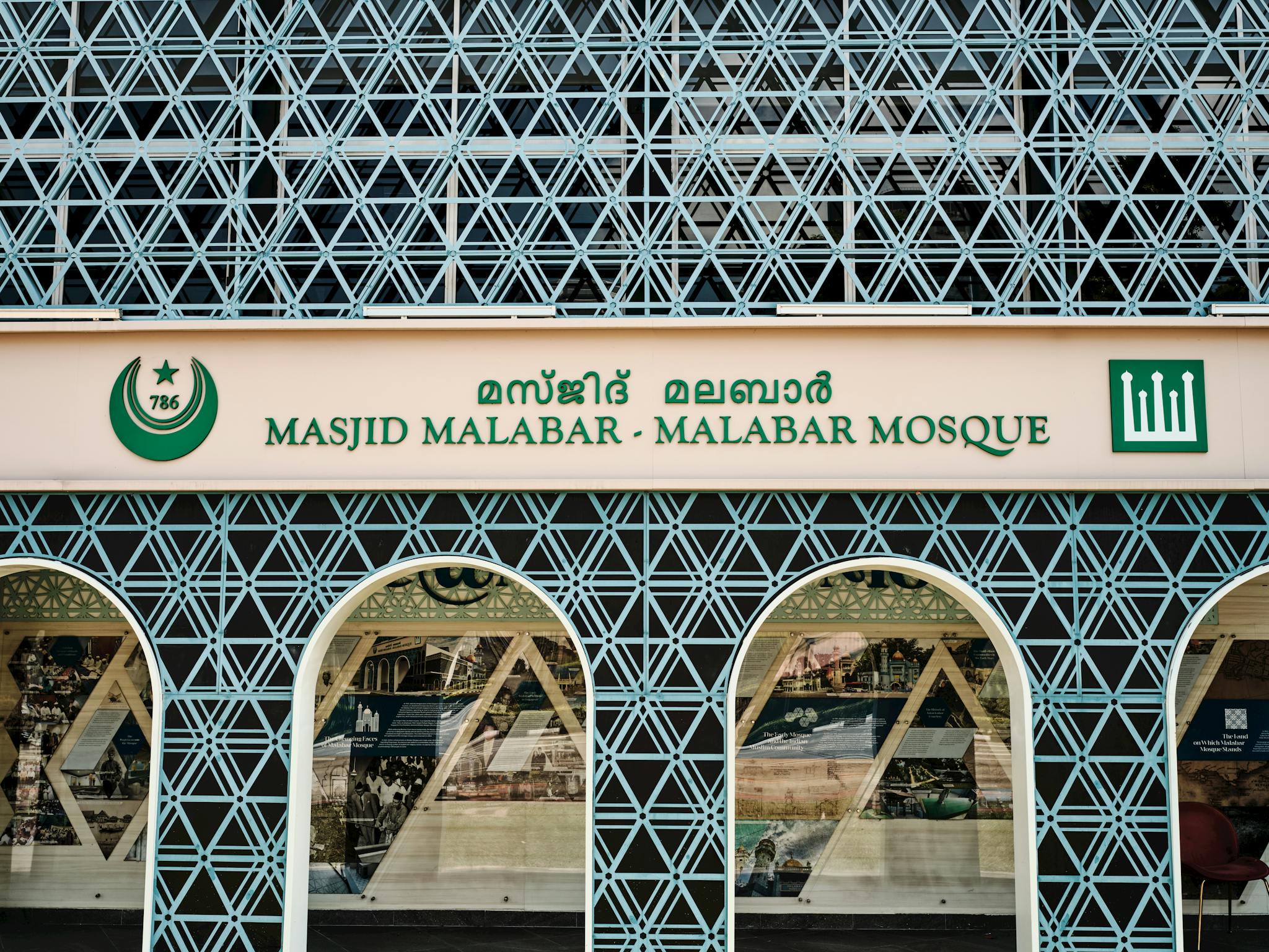 Front view of the geometric facade and sign of Masjid Malabar Mosque in Singapore.