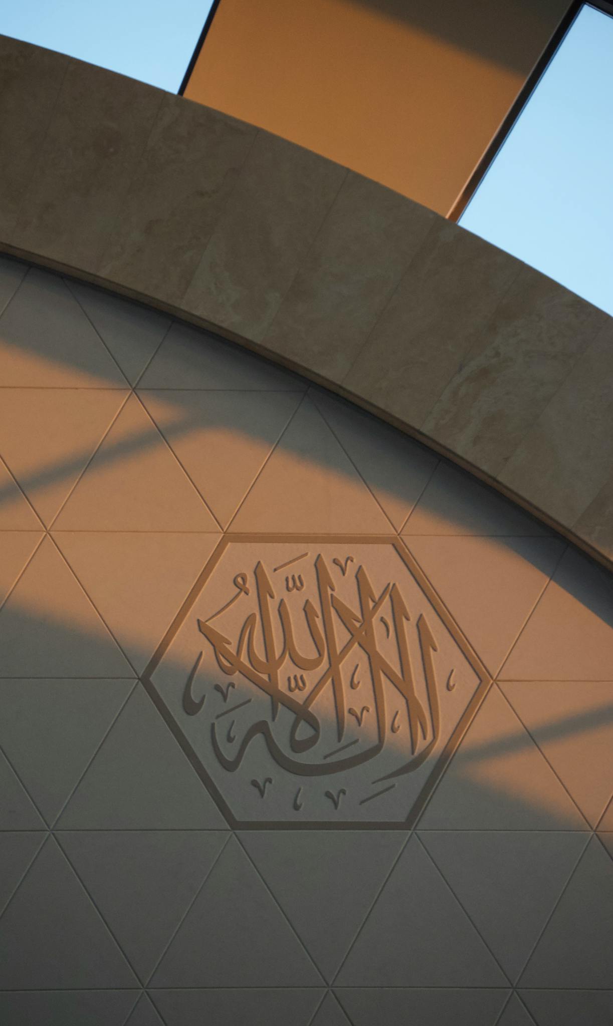 Intricate Islamic geometric wall art highlighting architectural elegance in a prayer setting.